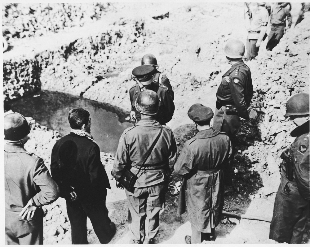 American officers bearing witness at a liberated Nazi camp in April 1945.